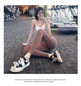 Detail van een high-waist yoga legging met push-up effect en sportbeha in de sportschool