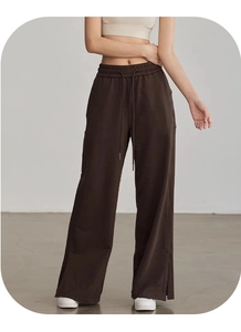 Dettaglio dei pantaloni sportivi a gamba larga con coulisse in vita e spacco laterale