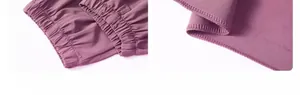 Detail view of elastic cuffed ankles and flatlock stitching on purple joggers