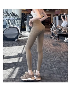 Detail van de kaki yoga-legging met hoge taille en perzik-bilnaad in de sportschool