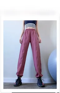 Detail of high waist grey-pink jogger pants with elastic waistband and hidden zip pockets