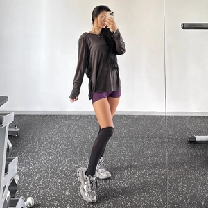 Relaxed fit dark taupe long sleeve yoga top paired with gym wear for a sporty style