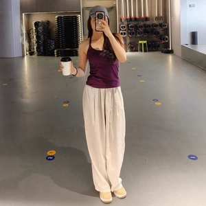 Eng anliegendes lila Yoga-Top mit beiger weit geschnittener Hose für Fitness und Sport