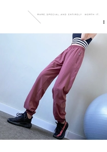 Close-up of high-waist maroon athletic joggers featuring a side metal zipper pocket