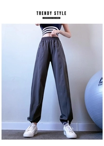 Detailed side view of high-waist dark grey jogger pants with functional zipper pockets