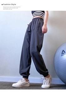 Detail of high waisted dark grey joggers featuring elastic waistband and side zipper pockets
