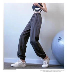 Detail view of high waist loose joggers with elastic cuffs and side zipper pockets