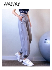 Detail view of high waist elastic waistband and side zipper pocket on gray joggers