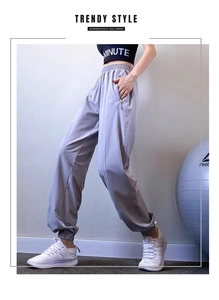 Close-up of high-waisted gray joggers showing side zipper pockets and quick-dry fabric texture
