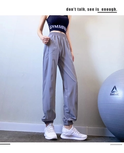 Detail of high waist grey-purple sports pants with elastic cuffs and side pockets