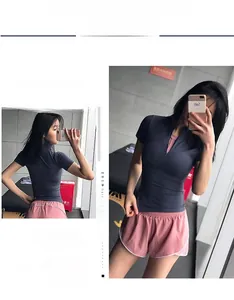 Detail of slim-fit sportswear set showing blue top with pink collar and matching shorts
