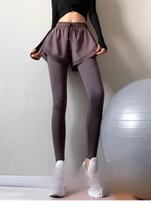 Dettaglio dei leggings viola a vita alta con coulisse e gonna a strati per il fitness