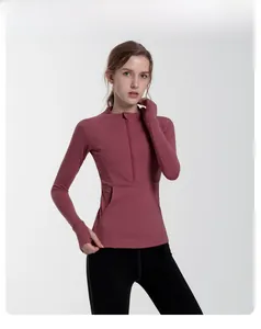 Detail of a dusty rose fitness top showing the half-zip collar and thumbhole sleeves