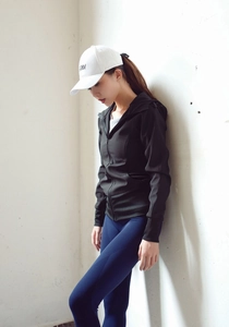 Détail de la veste de sport noire slim à capuche et du legging bleu texturé