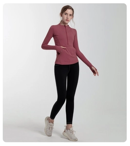 Detail view of pink half-zip workout top with thumbholes and black fitness leggings