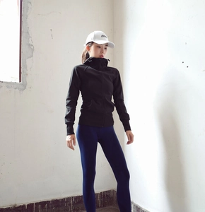 Détail d'un sweat à capuche noir ajusté avec col montant et casquette de sport blanche
