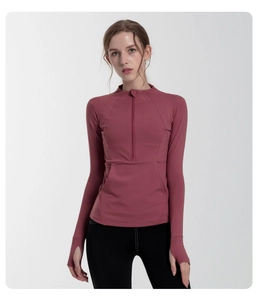 Detail of half-zip slim fit yoga top with thumbholes in dusty rose pink breathable fabric