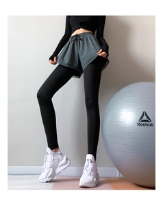 Dettaglio dei pantaloni yoga a vita alta finti due pezzi e leggings fitness snellenti con pantaloncini