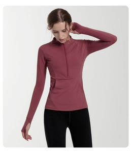 Detail view of dry rose sports top featuring a half-zip stand collar and thumbhole cuffs