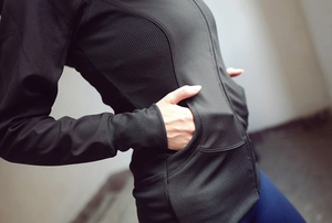Détail de la veste de sport noire cintrée avec texture côtelée et poches latérales
