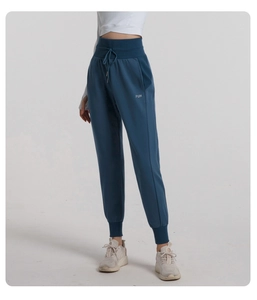 Detail view of high waist drawstring jogger pants in fog blue with PUH side print