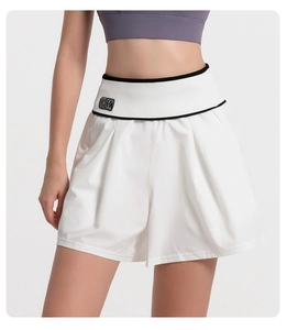 Detail of high waisted white sports shorts featuring a BK logo and ribbed waist design