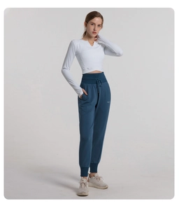 Detail of high-waist drawstring joggers with functional side pocket and logo detail