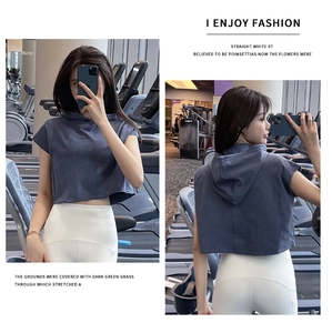 Μπροστινή και πίσω όψη του αθλητικού crop top με κουκούλα και λευκό κολάν στο γυμναστήριο