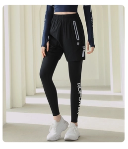 Dettaglio dei pantaloni sportivi 2-in-1 neri con tasca a zip e scritta RDPOWER laterale
