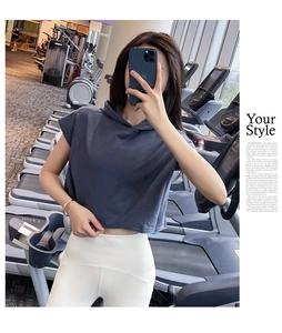 Λεπτομέρεια από σκούρο γκρι crop top με κουκούλα και λευκό ψηλόμεσο παντελόνι γιόγκα