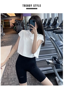 Λεπτομέρεια από λευκό cropped top με κουκούλα και μαύρο σορτς fitness στο μοντέλο
