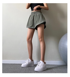 Detail view of olive green double-layer running shorts with high elastic waistband