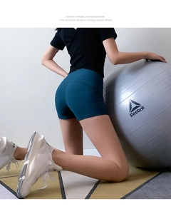 Close-up of high-waisted teal yoga shorts showing stretchy fabric and body-shaping fit