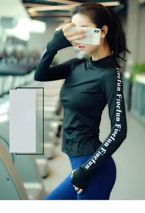 Details des schwarzen Slim-Fit Yoga-Tops mit Daumenlöchern und weißem Ärmelaufdruck