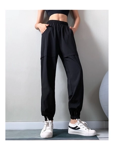 Detailed view of black jogger pants featuring elastic high waistband and cuffed ankles