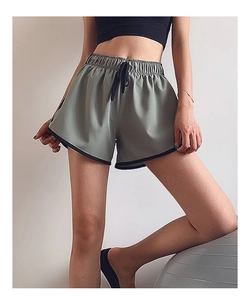 Détail du short de sport vert gris avec taille à cordon et bordure noire contrastée