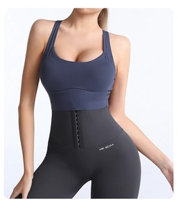 Dettaglio di leggings grigi a vita alta con fibbia a tre file e canotta sportiva blu navy
