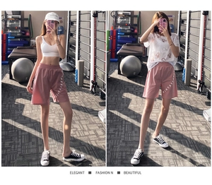 Pantaloncini sportivi rosa larghi con scritta bianca in un ambiente da palestra