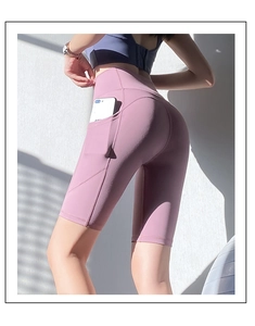 Détail d'un short de yoga taille haute avec poche latérale montrant un téléphone