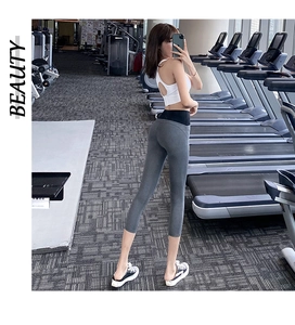 Detail view of high waist yoga leggings with contrast black waistband in a gym setting