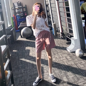 Set sportivo da donna con t-shirt bianca stampata e pantaloncini da fitness rosa