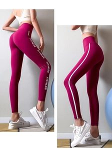 Detail showing the white FITNESS print and side stripes on high-waist sports leggings
