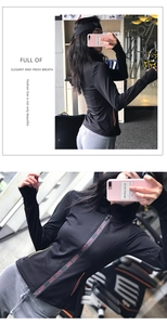 Detail of slim-fit sports jacket featuring red letter webbing on zipper and thumbhole cuffs
