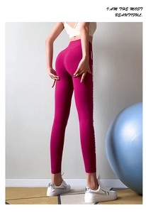 Detail of pink high waist yoga leggings with white fitness lettering and peach lift effect