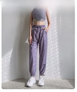 Détail du jogging violet taille haute avec cordon de serrage et chevilles resserrées