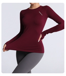 Detail of burgundy long sleeve yoga top featuring thumbholes and Neverstop chest logo