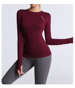 Close-up of slim-fit burgundy yoga top with thumbholes and white lettering detail