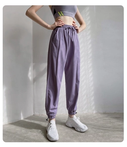 Gros plan du pantalon de jogging violet à taille haute montrant le drapé et les poignets