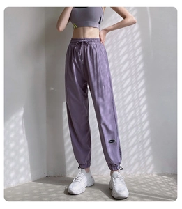 Détail du jogging violet avec ourlets à cordon réglable et écusson de logo brodé