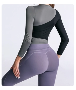 Détail du haut de yoga bicolore gris et noir avec un legging violet extensible et galbant